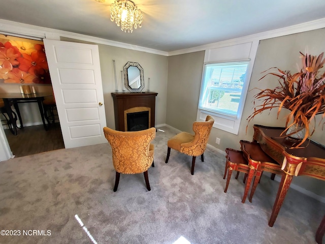 sitting room with carpet, ornamental molding, a fireplace, and an inviting chandelier