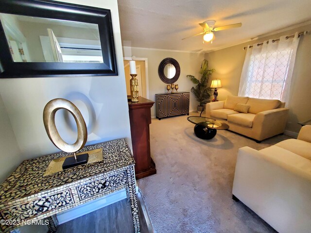 living room with crown molding, carpet, and ceiling fan