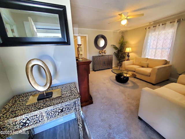 carpeted living room featuring crown molding and ceiling fan