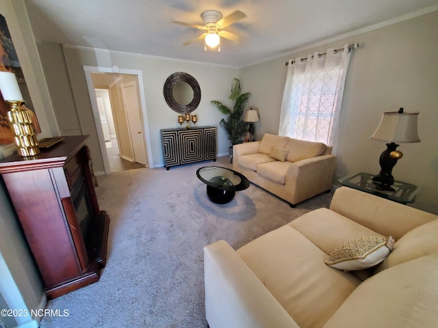 carpeted living room featuring ceiling fan and ornamental molding