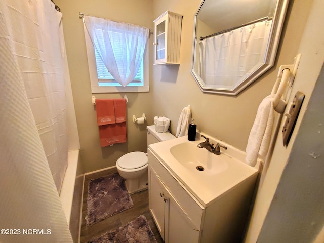 bathroom featuring baseboards, vanity, and toilet