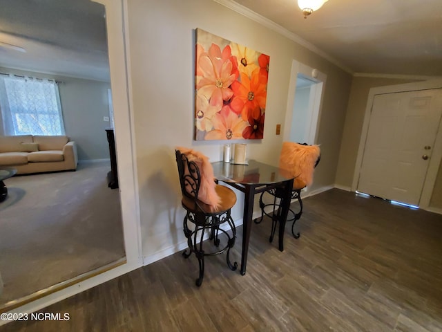 dining area with ornamental molding, baseboards, and wood finished floors