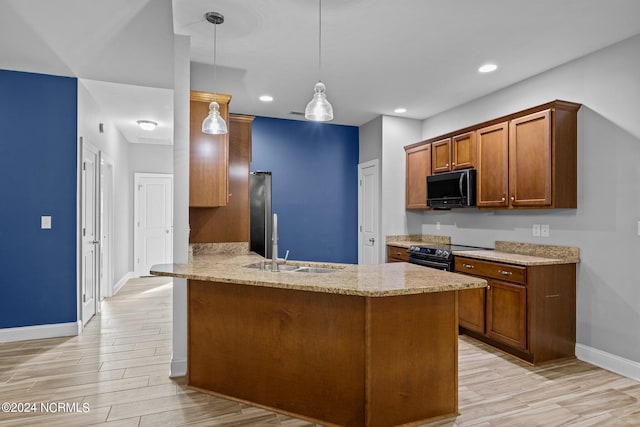 kitchen with hanging light fixtures, light wood-type flooring, light stone counters, black appliances, and kitchen peninsula