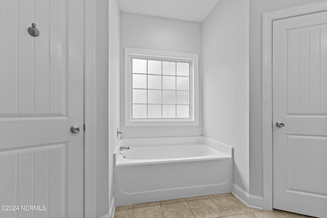 bathroom with a tub and tile patterned floors