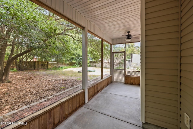 unfurnished sunroom with ceiling fan