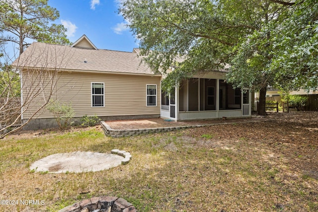 rear view of house featuring a lawn and a sunroom