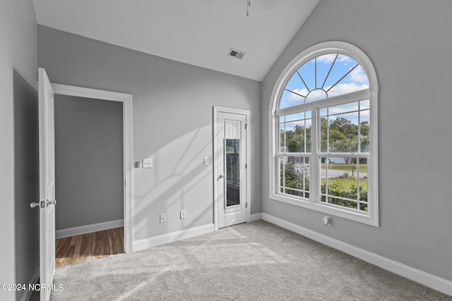 unfurnished room featuring lofted ceiling and carpet