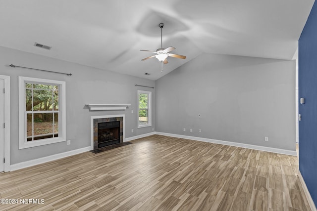 unfurnished living room with lofted ceiling, light hardwood / wood-style flooring, ceiling fan, and a tile fireplace