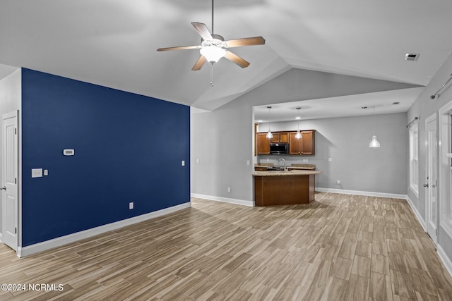 unfurnished living room featuring light wood-type flooring, ceiling fan, lofted ceiling, and sink