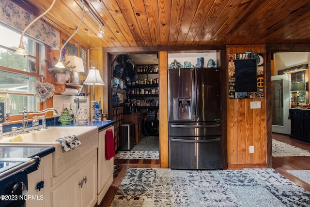 kitchen with a sink, dark wood-type flooring, white cabinets, stainless steel refrigerator with ice dispenser, and wooden ceiling