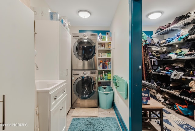 laundry room with laundry area, stacked washer / dryer, light tile patterned flooring, and a sink