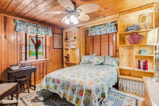 bedroom featuring wooden walls, wood ceiling, and visible vents