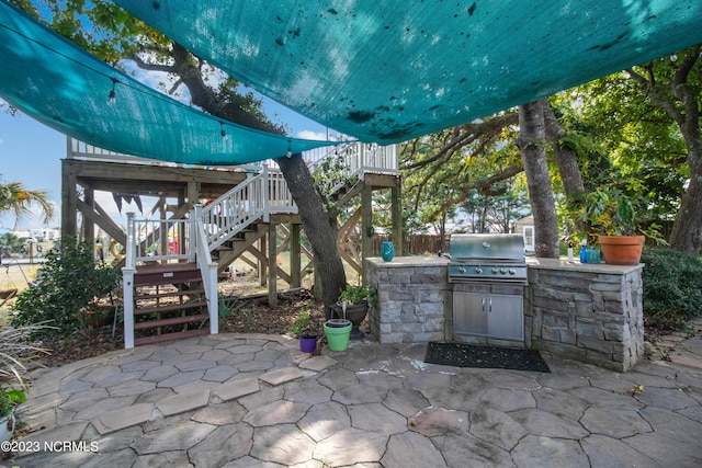 view of patio / terrace with stairway, area for grilling, exterior kitchen, and fence