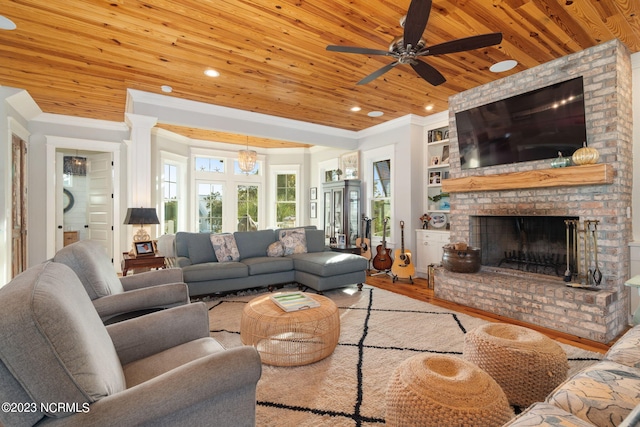 living room with wood ceiling, built in features, a brick fireplace, ceiling fan, and light hardwood / wood-style flooring