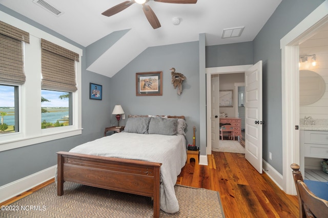 bedroom with vaulted ceiling, ensuite bathroom, dark hardwood / wood-style floors, and ceiling fan