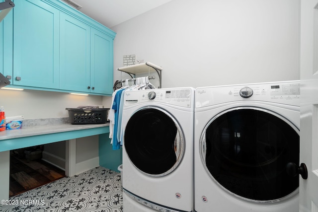 laundry area featuring light tile patterned floors, cabinets, and washing machine and clothes dryer