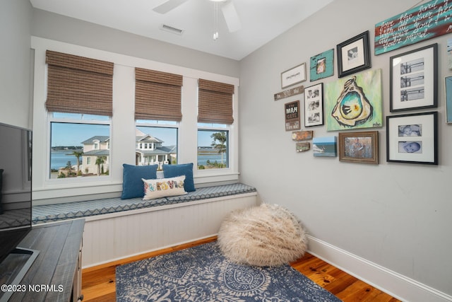 living area with ceiling fan and hardwood / wood-style floors