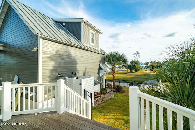 view of home's exterior with a deck with water view and a yard