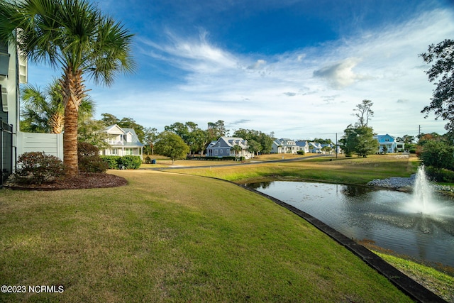 view of community with a water view and a yard