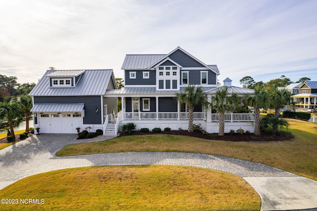 view of front facade with covered porch, a garage, and a front lawn