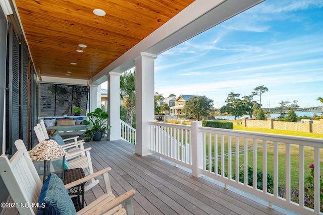 wooden terrace with a porch and a lawn