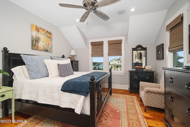 bedroom featuring lofted ceiling, light hardwood / wood-style flooring, multiple windows, and ceiling fan