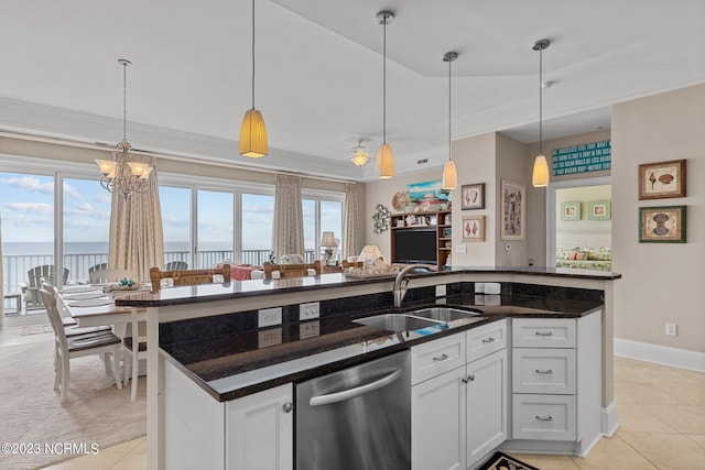 kitchen with stainless steel dishwasher, hanging light fixtures, light tile flooring, and white cabinets