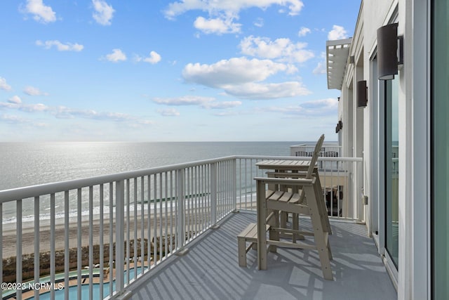 balcony featuring a water view and a fenced in pool