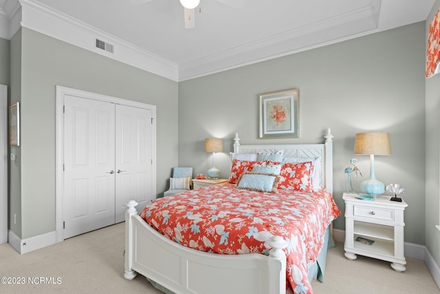 carpeted bedroom with ornamental molding, a closet, and ceiling fan