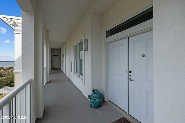 property entrance with a water view and a balcony