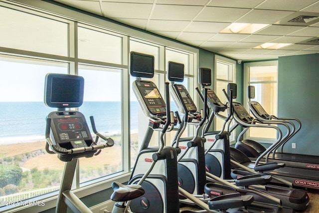 exercise room featuring a water view and a drop ceiling