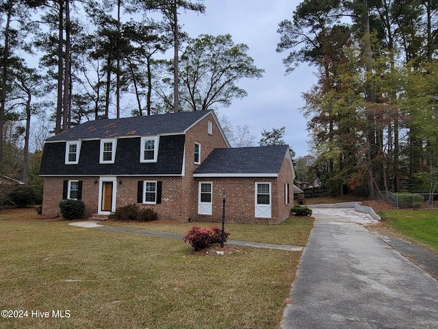 colonial-style house featuring a front lawn