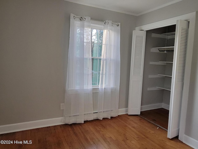 interior space with hardwood / wood-style flooring, ornamental molding, and a closet