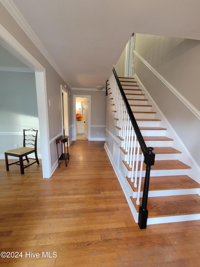 stairway featuring wood-type flooring and ornamental molding