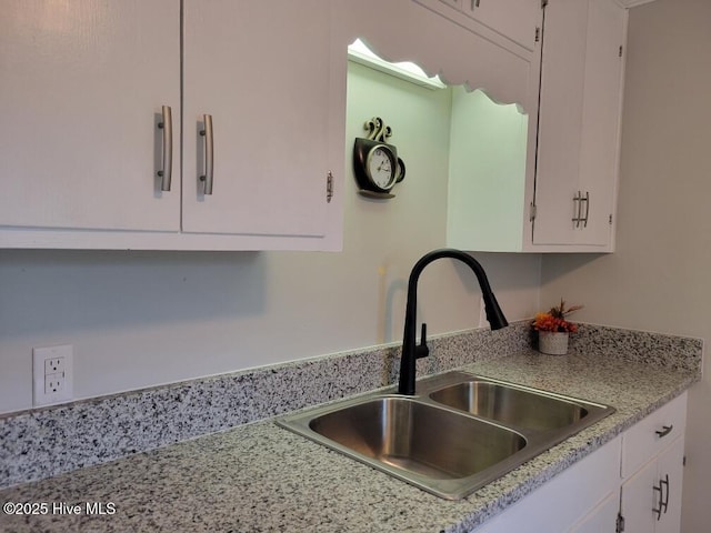 kitchen featuring white cabinetry and sink