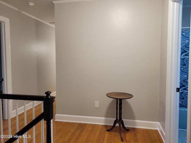 stairs with hardwood / wood-style flooring and crown molding