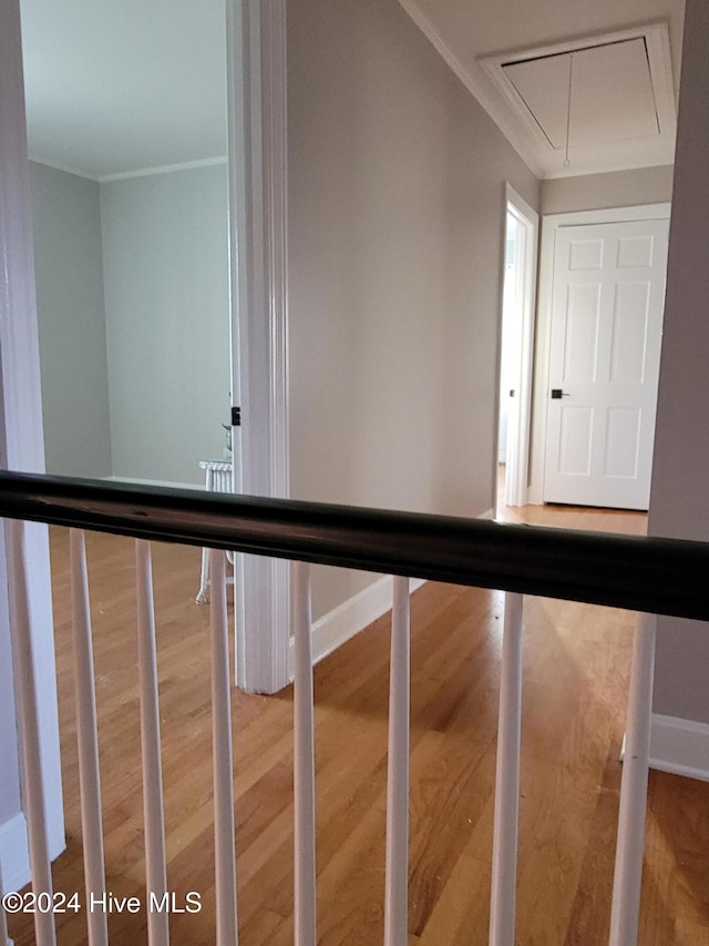 stairway featuring hardwood / wood-style floors and ornamental molding