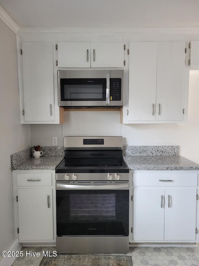 kitchen with crown molding, white cabinets, light stone countertops, and appliances with stainless steel finishes