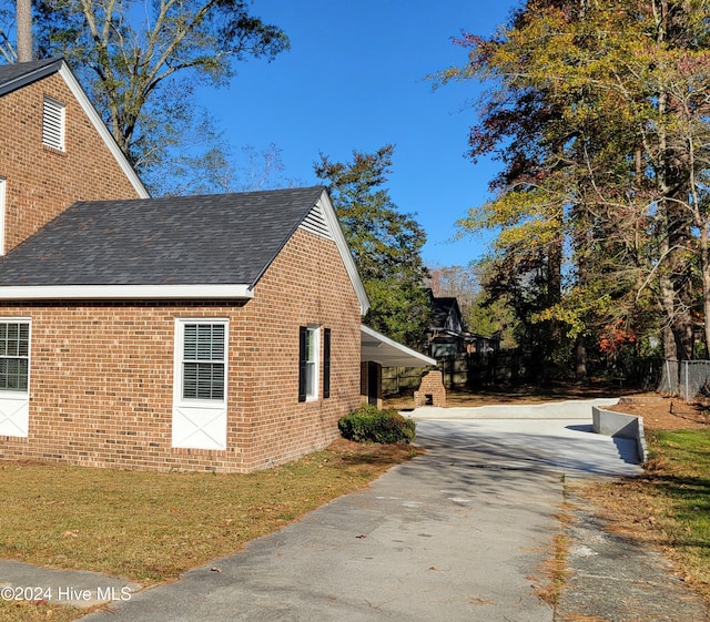 view of home's exterior featuring a yard and a carport