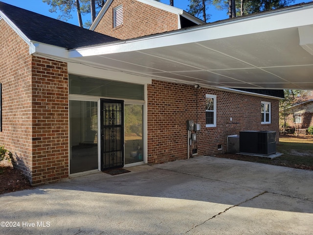 rear view of house with central AC unit and a patio area