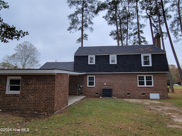 back of property with a yard, a patio, and central air condition unit