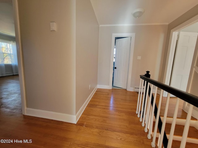 hall featuring baseboard heating, crown molding, and light hardwood / wood-style flooring