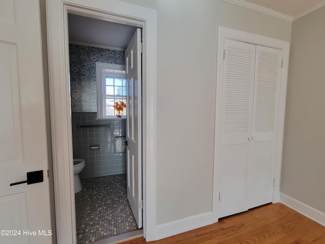 hall with hardwood / wood-style flooring and tile walls