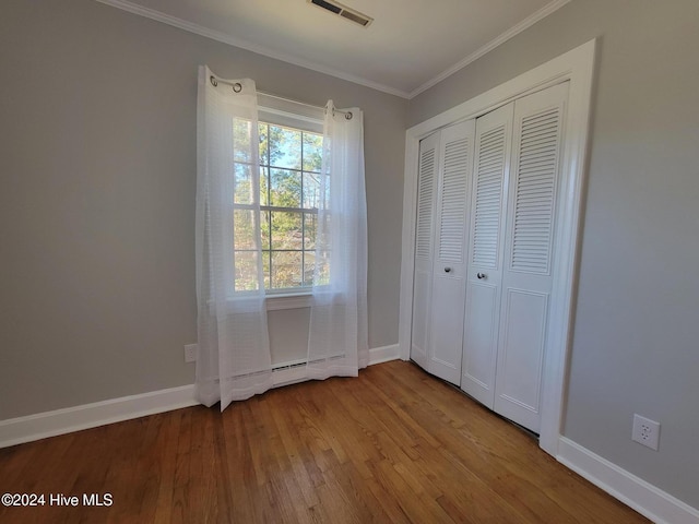 unfurnished bedroom featuring crown molding, a closet, and light hardwood / wood-style flooring