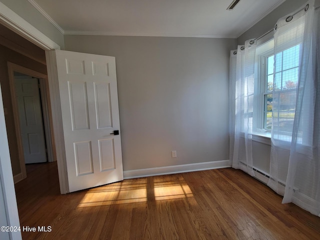 unfurnished room with wood-type flooring and ornamental molding