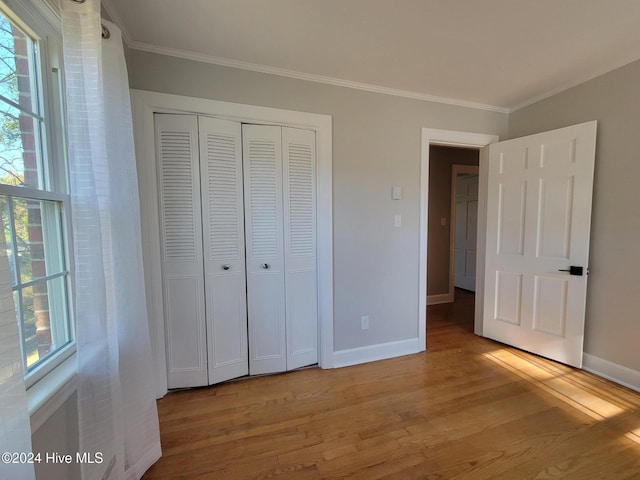 unfurnished bedroom with multiple windows, light hardwood / wood-style flooring, and ornamental molding