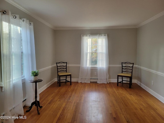 unfurnished room with wood-type flooring, crown molding, and baseboard heating