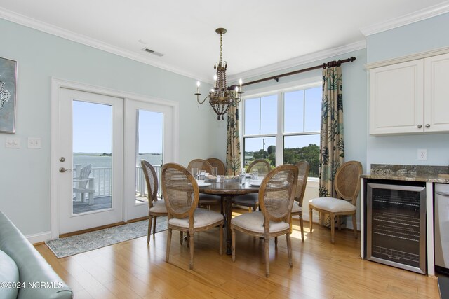 dining room with crown molding, wine cooler, light hardwood / wood-style floors, and a notable chandelier