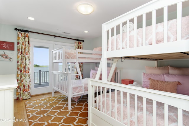 bedroom with wood-type flooring and access to exterior