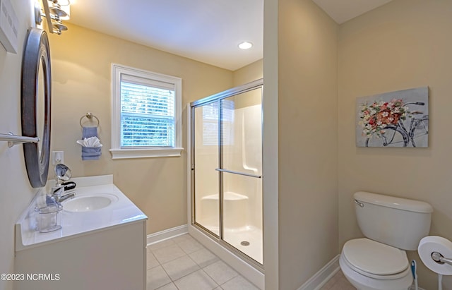 bathroom with a shower with shower door, vanity, tile patterned flooring, and toilet